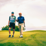 Two gentleman on a golf course having a conversation 